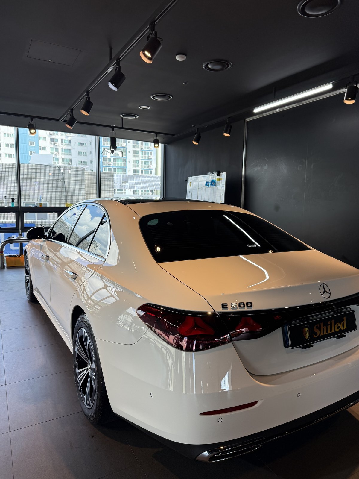 벤츠 E200 AMG 백색 신차 후측면 야간 조명 반사 - 부산 쉴드광택 신차코팅
